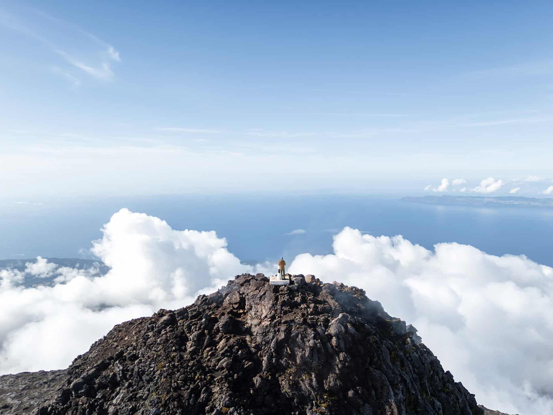 man standing on a mountain summit looking out at the horizon, representing the financial freedom and life planning goals of N2 Asset Management.